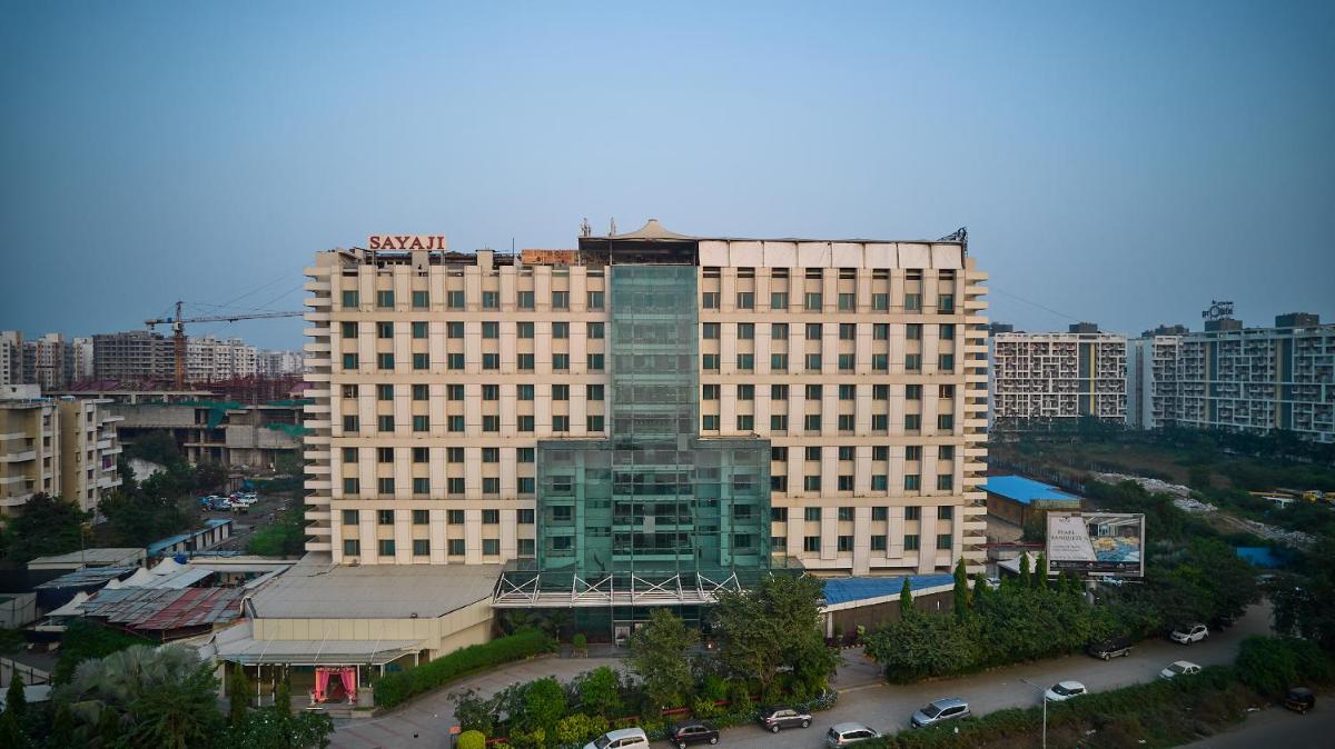 a large building in a city with a parking lot at Sayaji Pune in Pune
