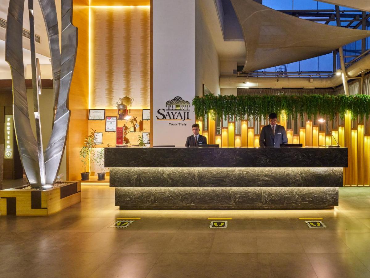 two men in suits standing at a bar in a lobby at Sayaji Pune in Pune