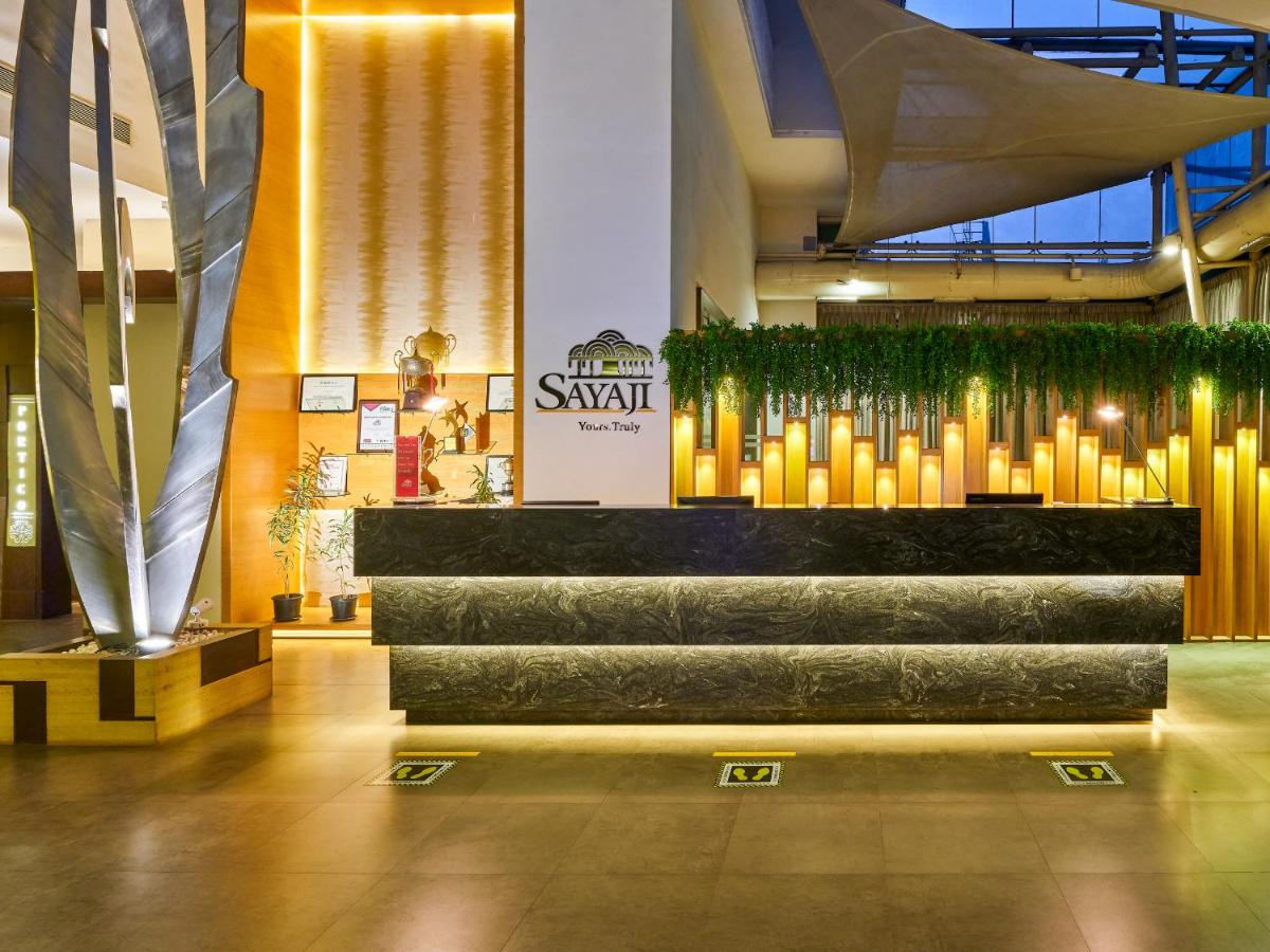 a lobby with a staircase and a sign in a building at Sayaji Pune in Pune