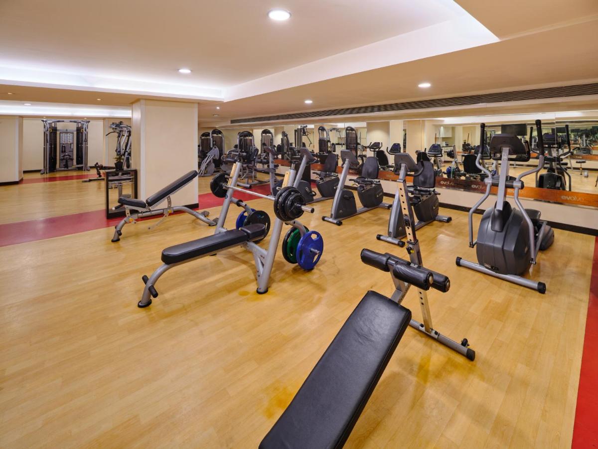 a gym with a lot of treadmills and exercise bikes at Sayaji Pune in Pune