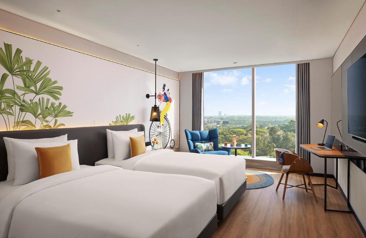a hotel room with a large bed and a large window at Hyatt Centric Hebbal Bengaluru in Bengaluru