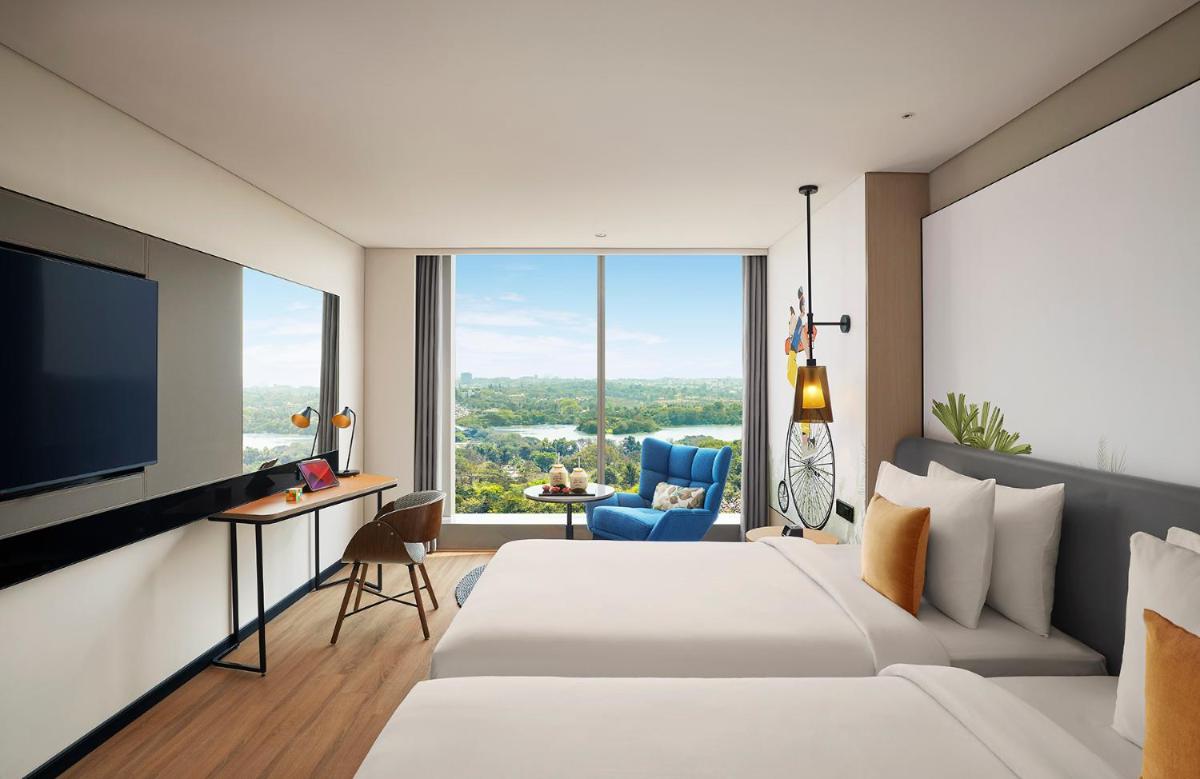 a hotel room with a bed and a flat screen tv at Hyatt Centric Hebbal Bengaluru in Bengaluru a hotel room with a bed and a flat screen tv at Hyatt Centric Hebbal Bengaluru in Bengaluru