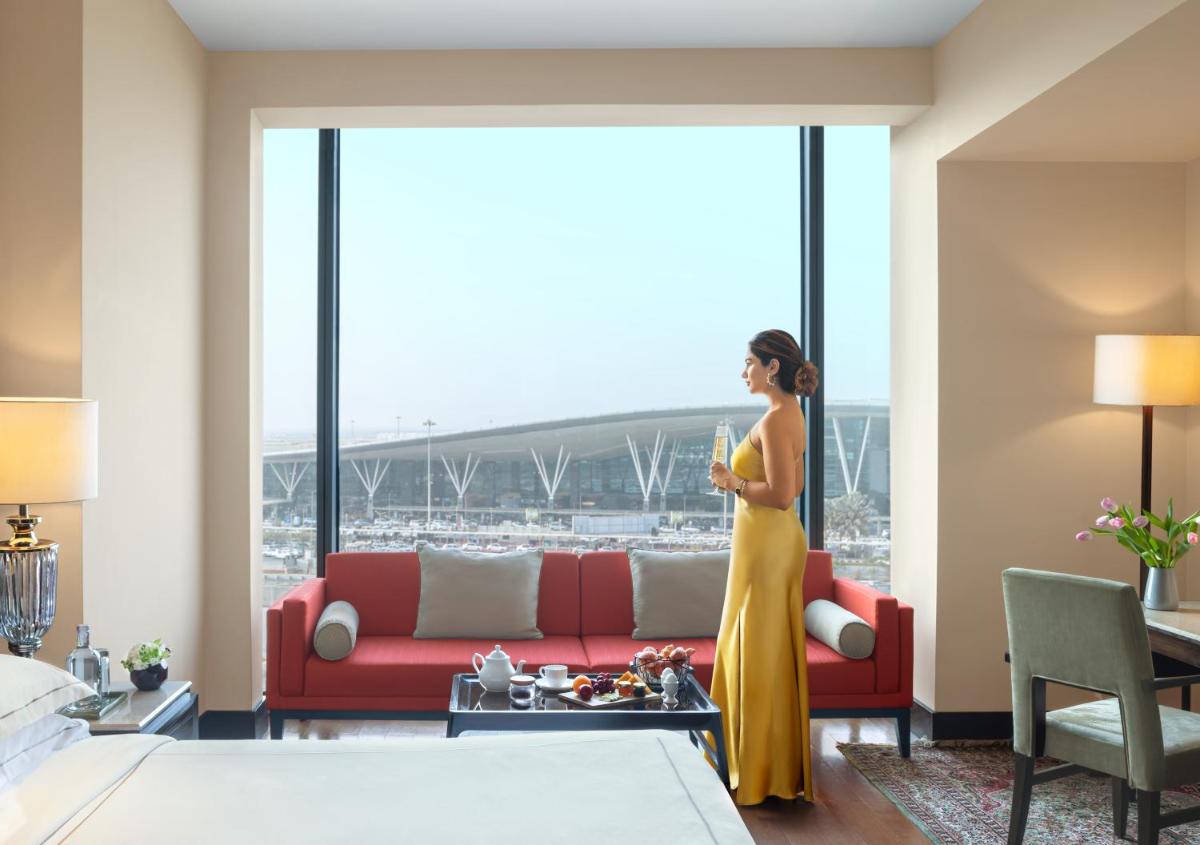 a woman in a yellow dress standing in a hotel room at Taj Bangalore in Devanahalli-Bangalore