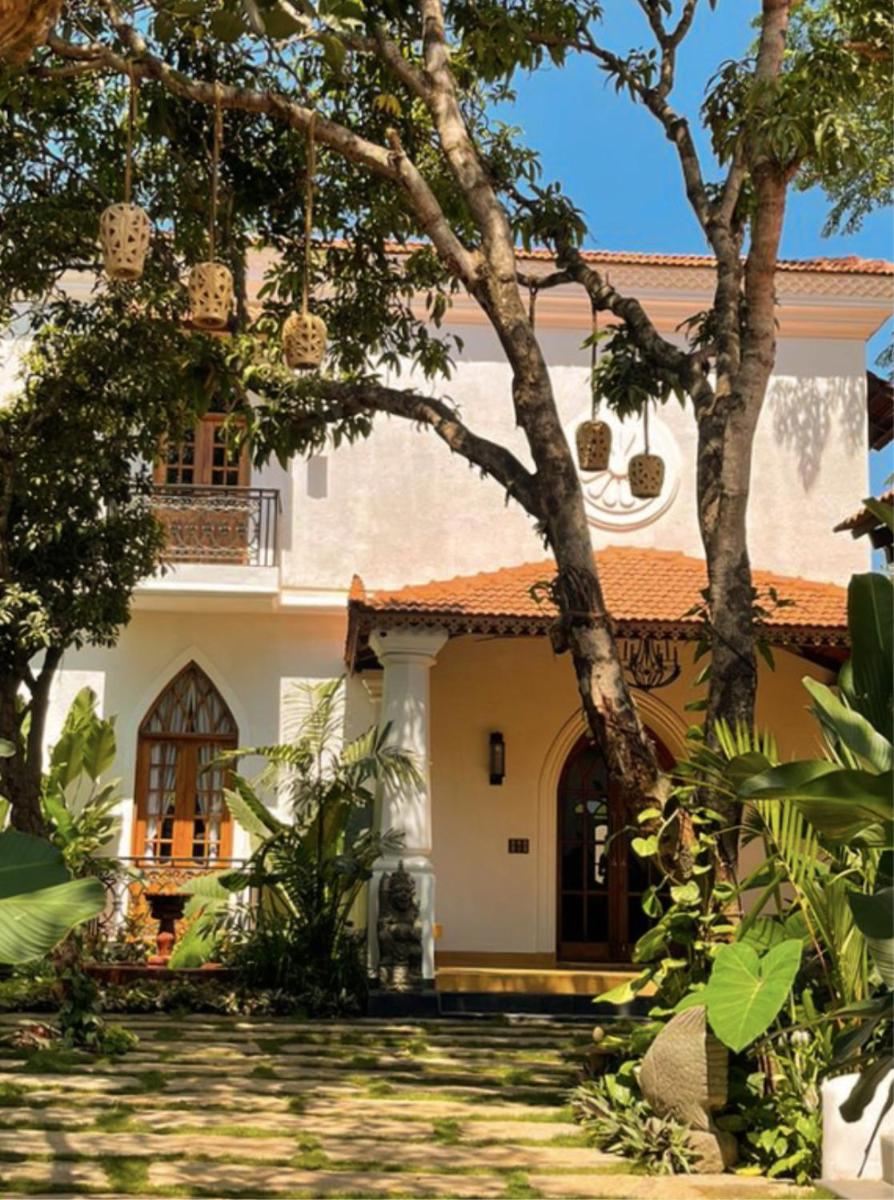 a house with a courtyard and trees at The Postcard Saligao in Calangute