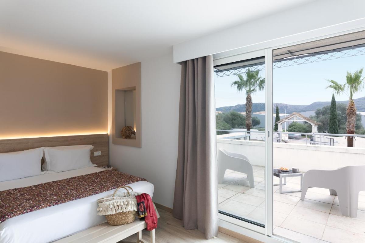 une chambre avec un lit et un balcon dans l'établissement Golfe Hôtel & Spa Porto-Vecchio, à Porto-Vecchio