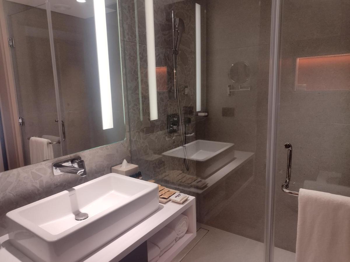 a bathroom with a white sink and a shower at Hyatt Centric Hebbal Bengaluru in Bengaluru