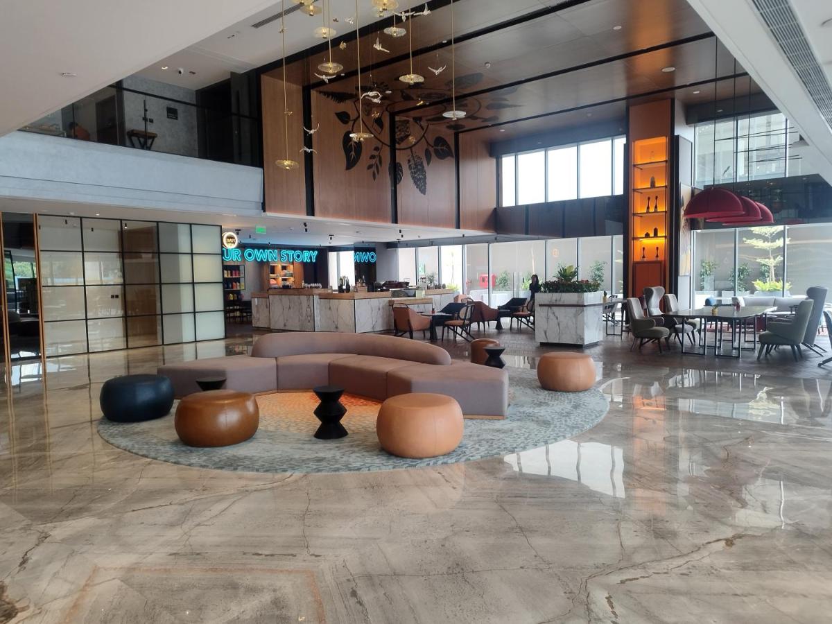 a lobby with couches and tables in a building at Hyatt Centric Hebbal Bengaluru in Bengaluru