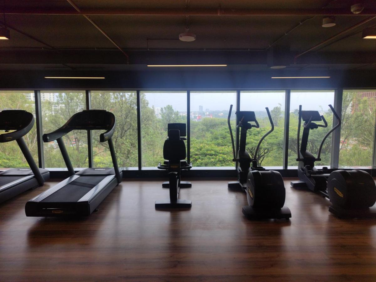 a gym with a bunch of treadms and pilates equipment at Hyatt Centric Hebbal Bengaluru in Bengaluru