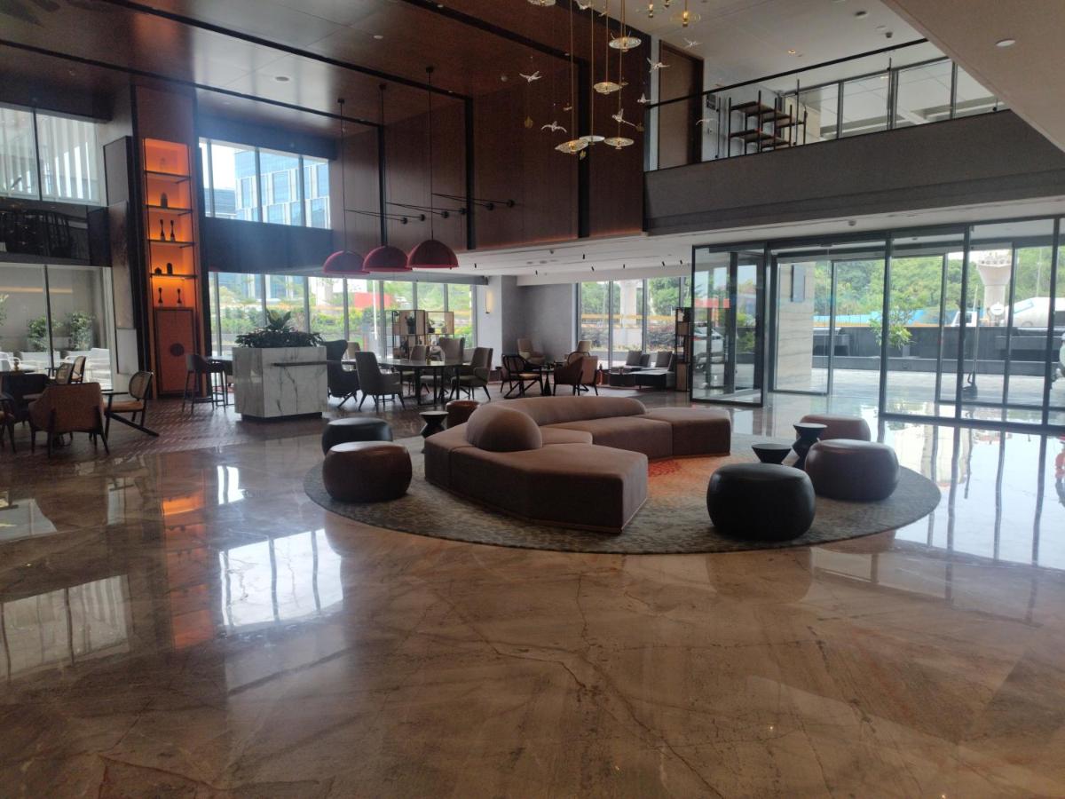 a lobby with couches and a table and chairs at Hyatt Centric Hebbal Bengaluru in Bengaluru