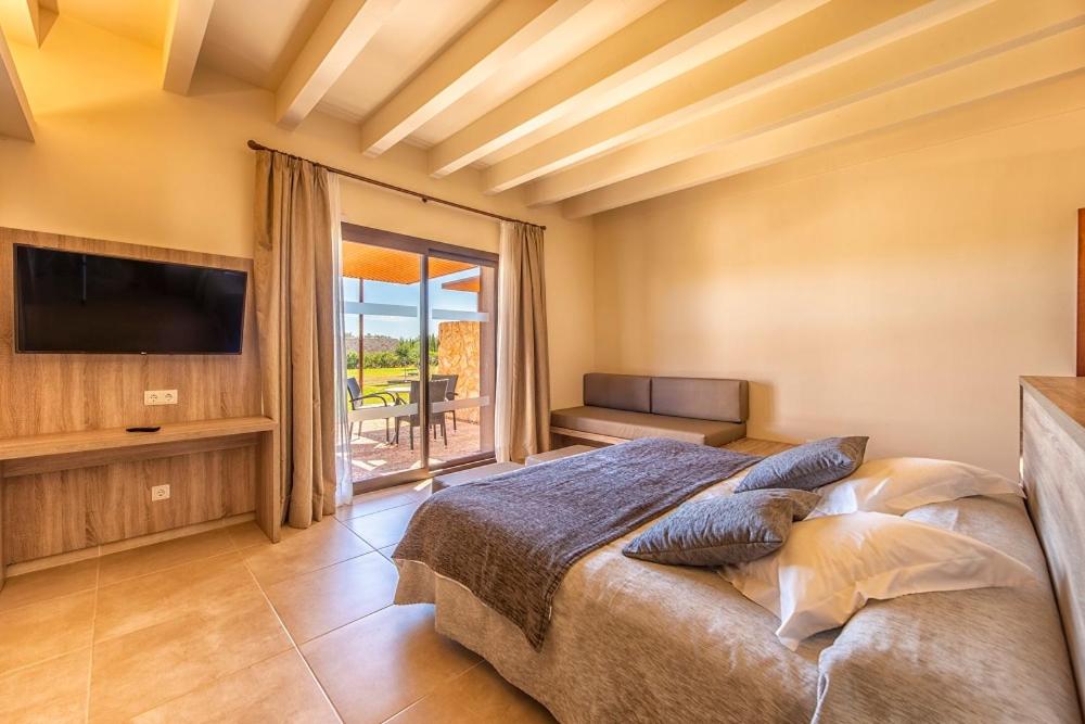 Un dormitorio con una cama grande y una ventana grande. en Hotel Son Trobat Wellness & Spa, en Sant Llorenç des Cardassar 45 fotos más