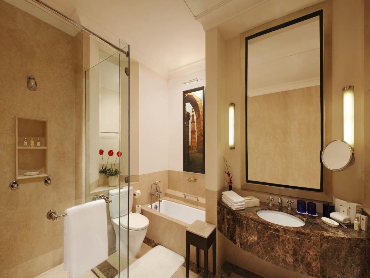 a bathroom with a tub and a toilet and a sink at Trident Gurgaon in Gurgaon
