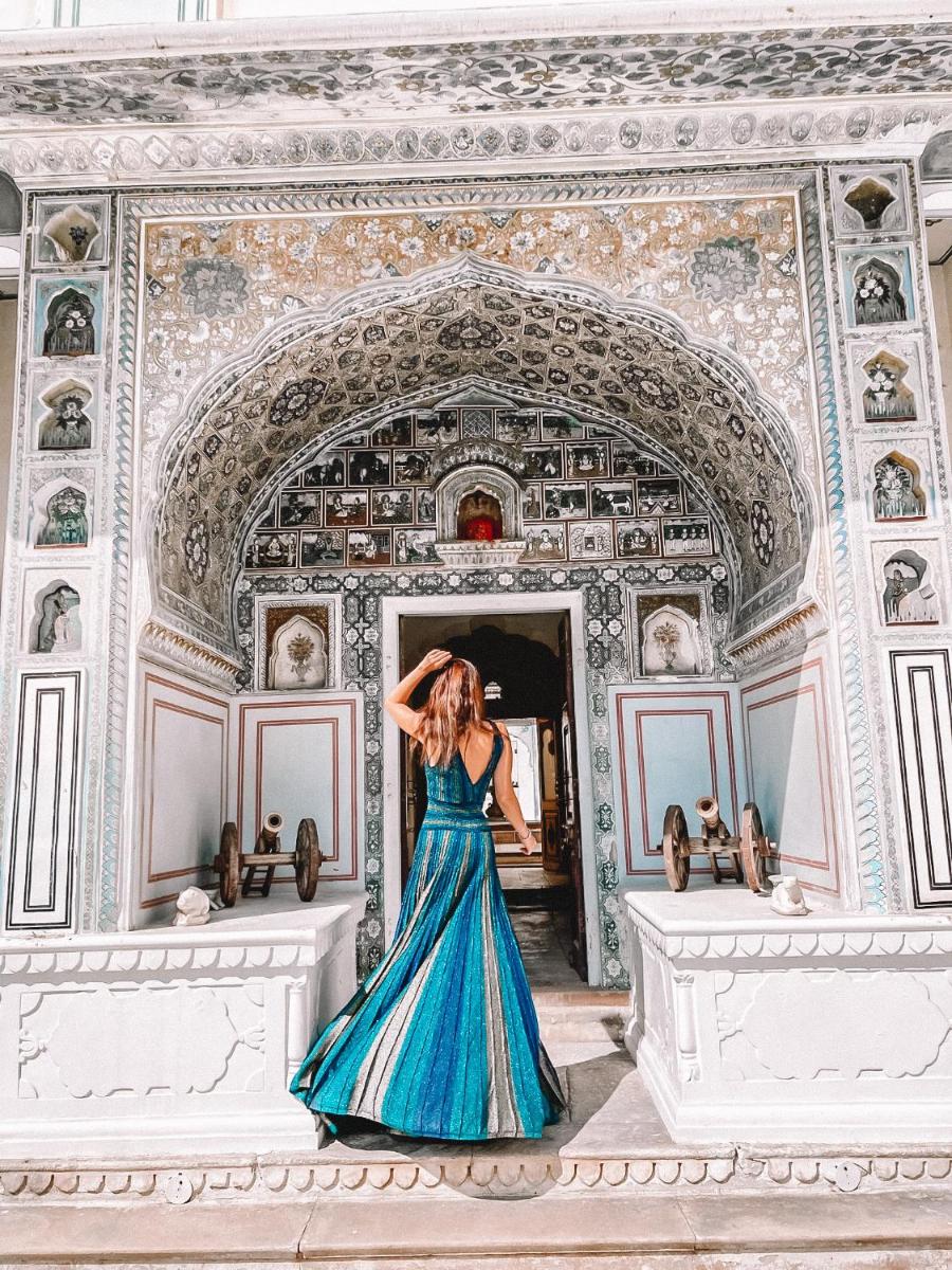 a woman in a blue dress standing in a building at The Raj Palace (Small Luxury Hotels of the World) in Jaipur