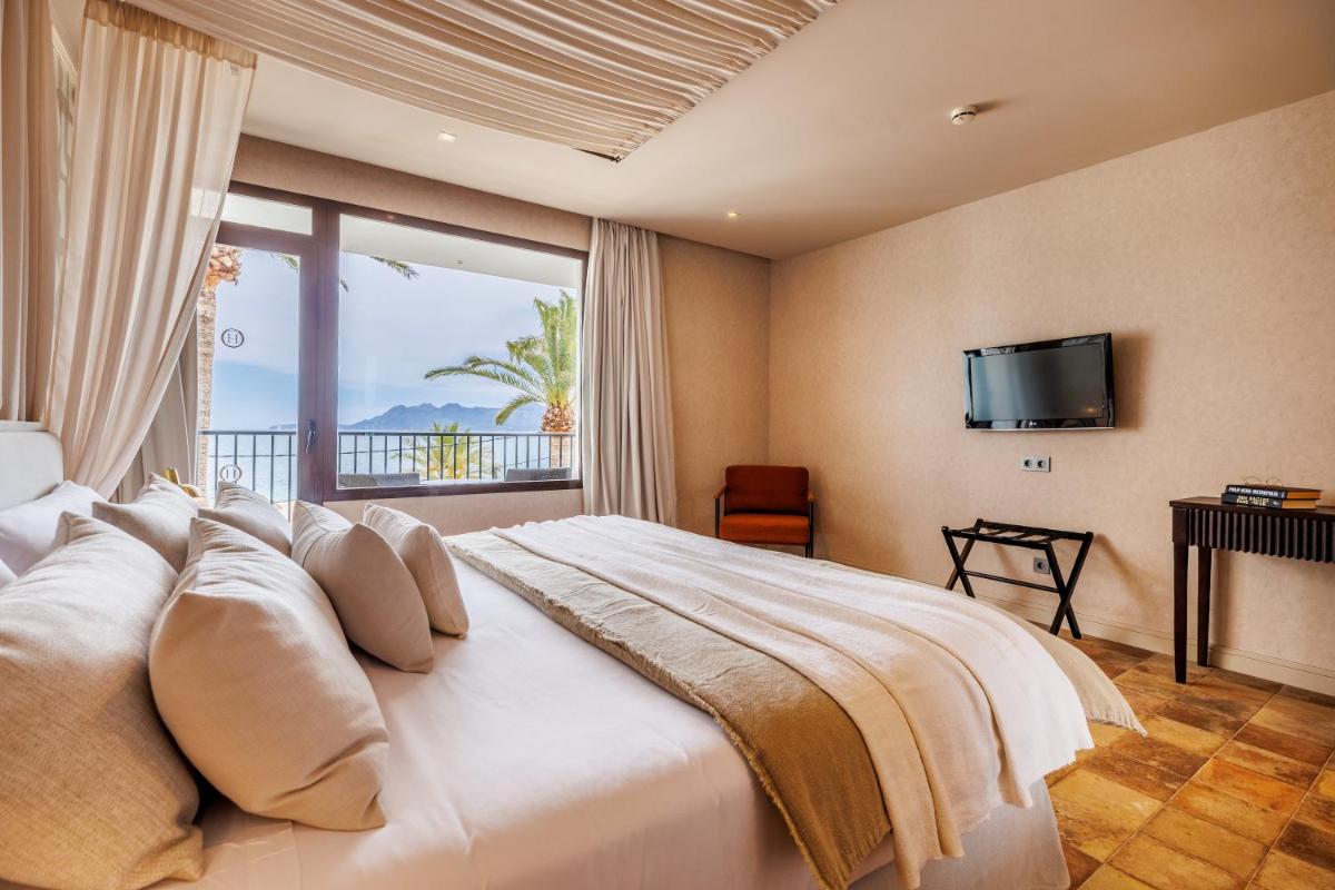 Un dormitorio con una cama grande con una ventana grande. en Hoposa Uyal, en Puerto Pollensa