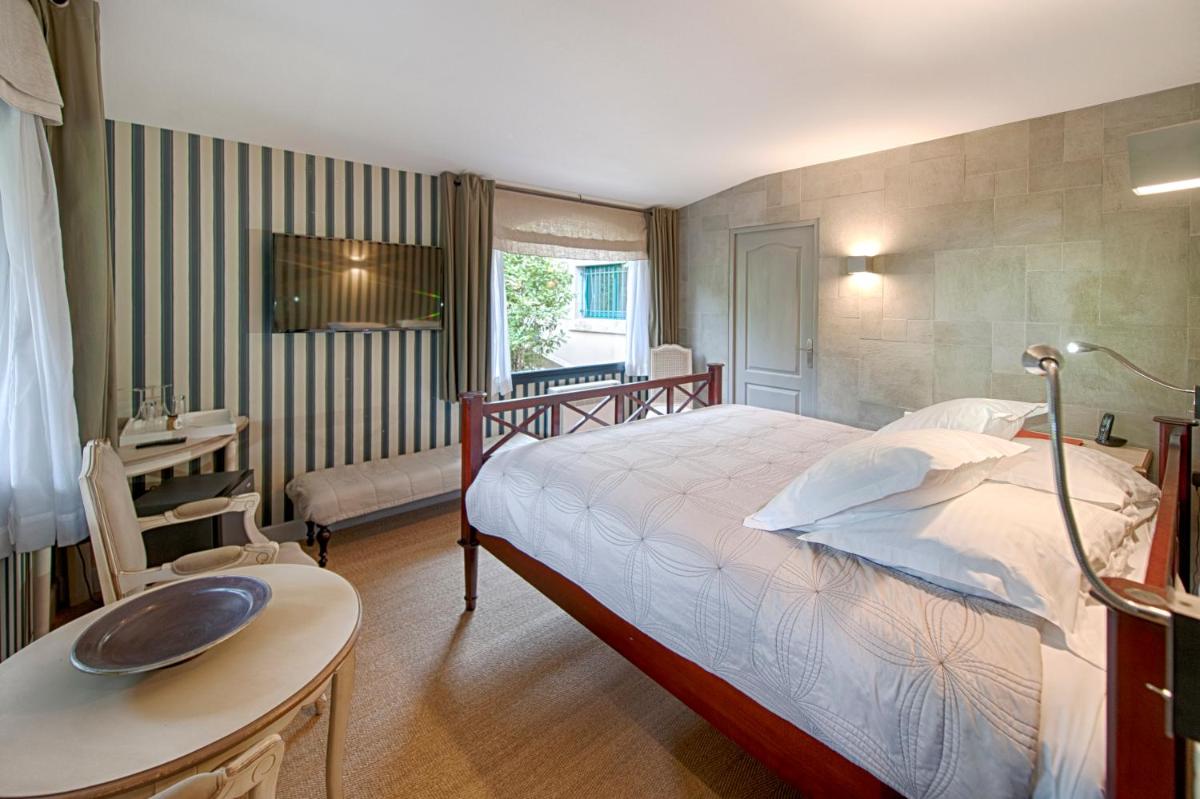 une chambre avec un lit, un bureau et une table dans l'établissement Du Côté Des Olivades, à Paradou