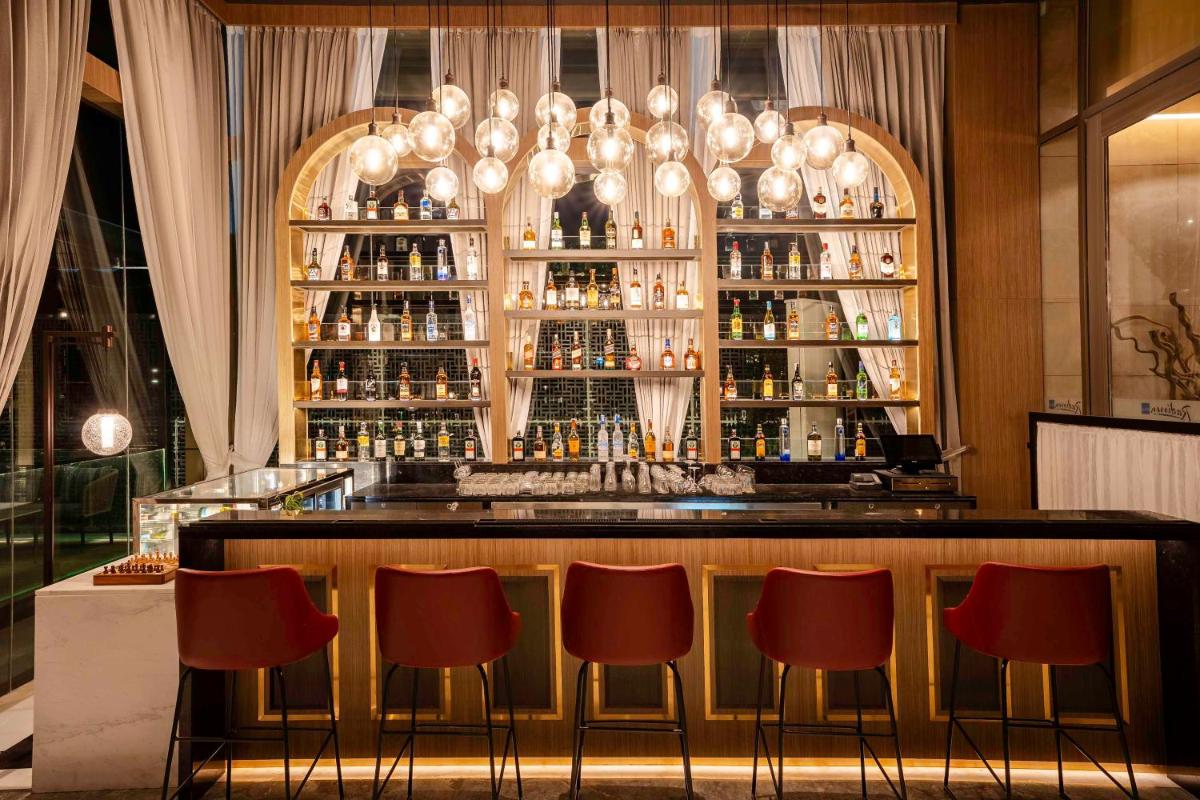 a bar with red chairs in a restaurant at Radisson Blu Hotel Amritsar in Amritsar