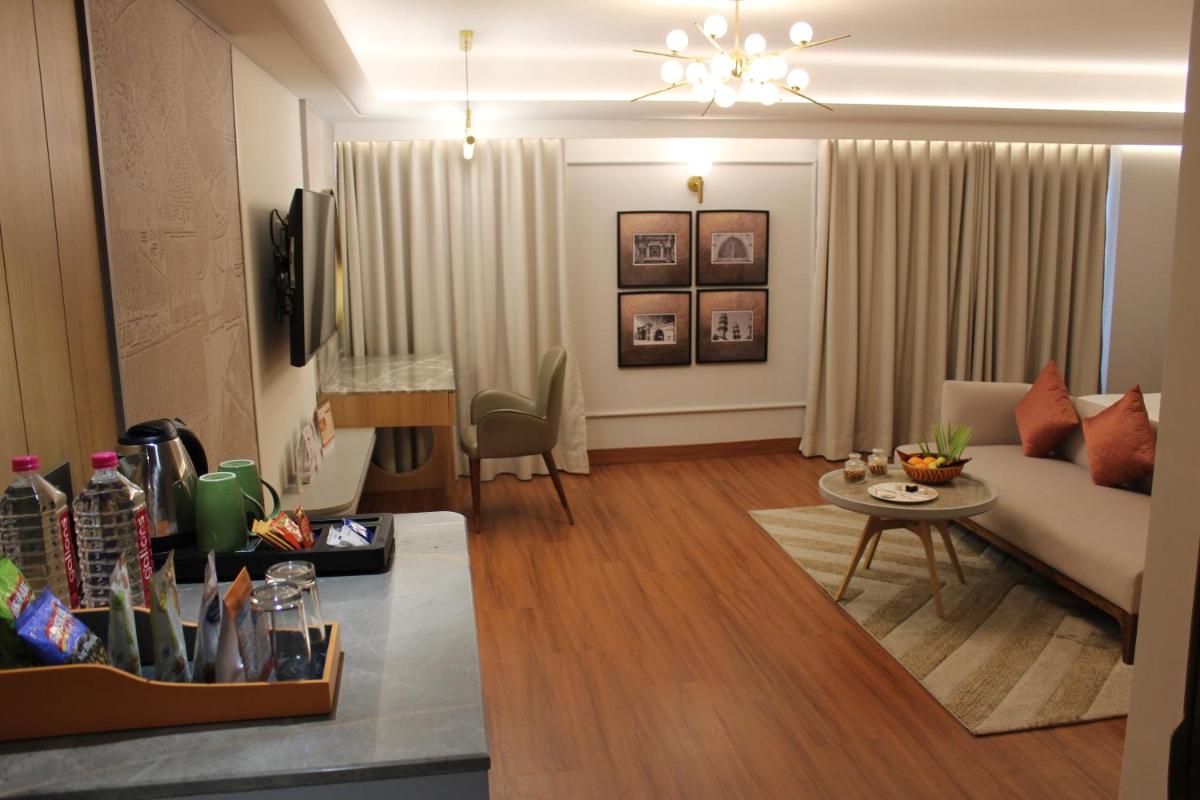 a living room with a couch and a table at Pride Plaza Hotel, Ahmedabad in Ahmedabad