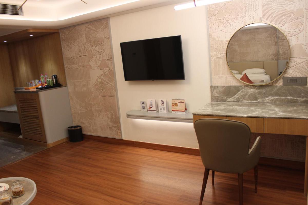 a waiting room with a chair and a mirror at Pride Plaza Hotel, Ahmedabad in Ahmedabad