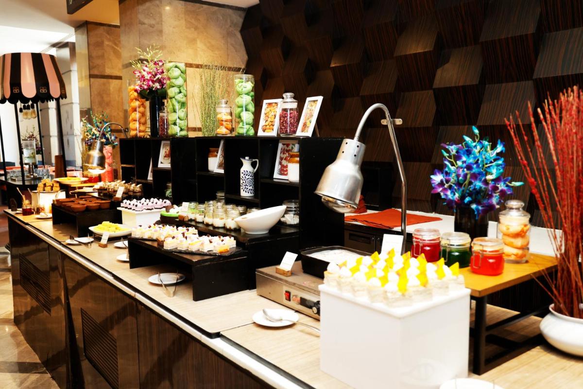 a buffet line in a restaurant with food on it at DoubleTree by Hilton Gurgaon New Delhi NCR in Gurgaon