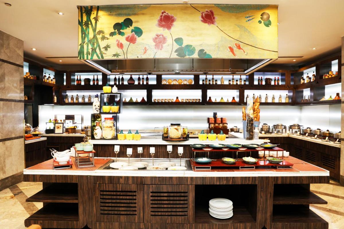 a restaurant with a counter with food on it at DoubleTree by Hilton Gurgaon New Delhi NCR in Gurgaon