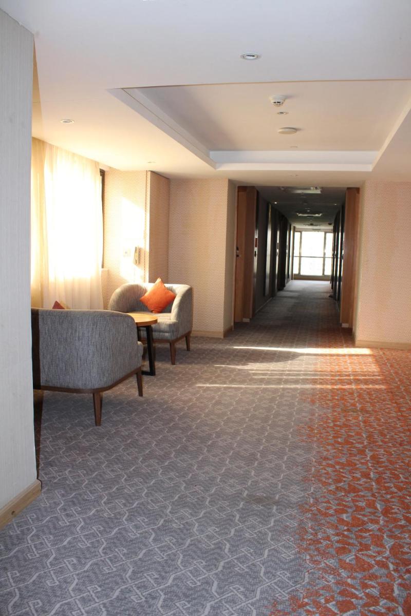 a hallway with couches and a table in a building at Pride Plaza Hotel, Ahmedabad in Ahmedabad