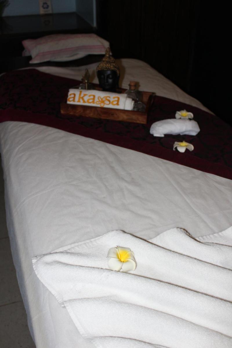 a bed with white towels and a flower on it at Pride Plaza Hotel, Ahmedabad in Ahmedabad