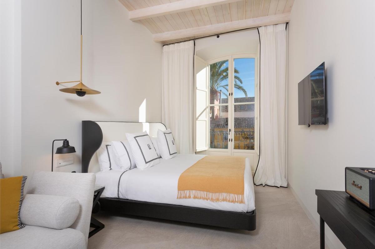 Un dormitorio con una cama y una ventana grande. en La Fonda Heritage Hotel Luxury, Relais & Châteaux, en Marbella