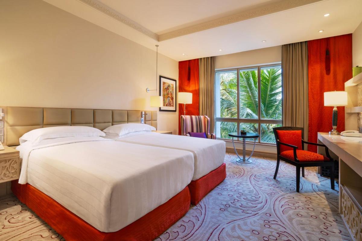 a hotel room with a large bed and a desk at ITC Maratha, a Luxury Collection Hotel, Mumbai in Mumbai