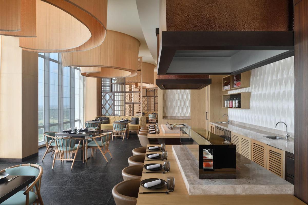 a restaurant with tables and chairs in a room at The Westin Kolkata Rajarhat in Kolkata a restaurant with tables and chairs in a room at The Westin Kolkata Rajarhat in Kolkata