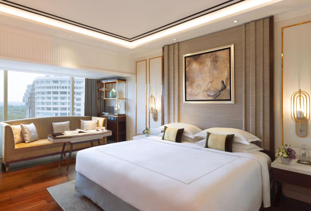 a bedroom with a large white bed and a couch at Taj MG Road Bengaluru in Bengaluru a bedroom with a large white bed and a couch at Taj MG Road Bengaluru in Bengaluru