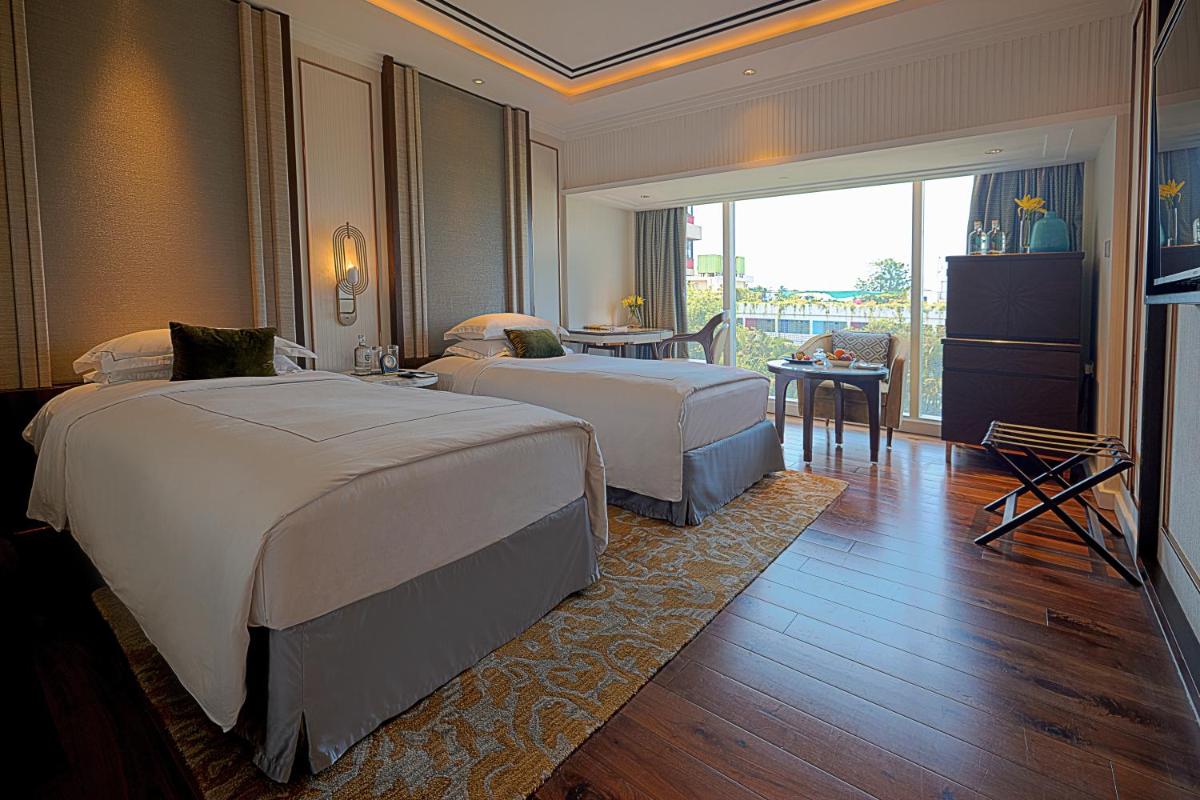 a hotel room with two beds and a dining room at Taj MG Road Bengaluru in Bengaluru a hotel room with two beds and a dining room at Taj MG Road Bengaluru in Bengaluru