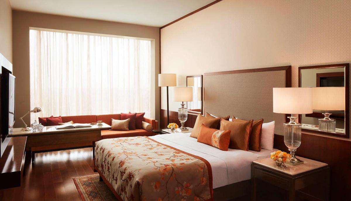 a hotel room with a bed and a large window at Taj Bangalore in Devanahalli-Bangalore