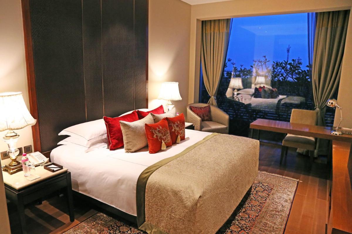 a hotel room with a large bed and a living room at Taj Bangalore in Devanahalli-Bangalore