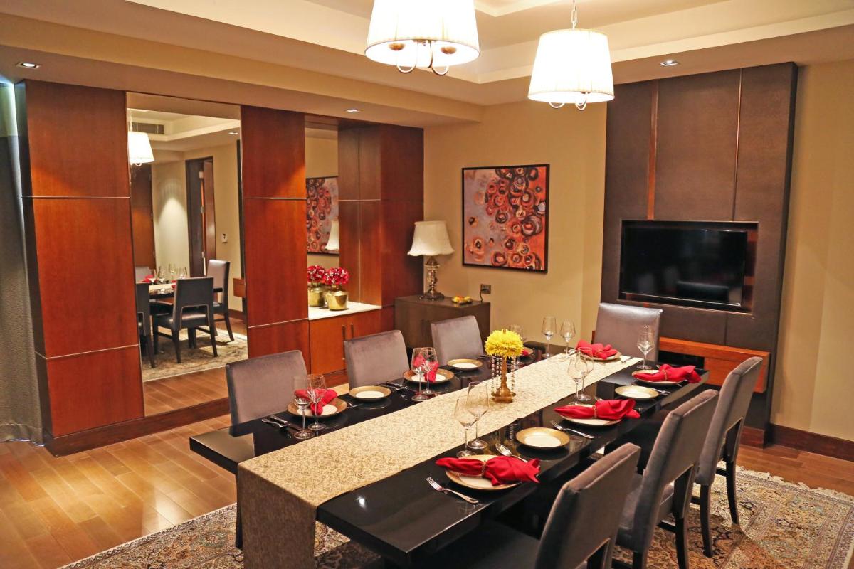 a dining room with a long table and chairs at Taj Bangalore in Devanahalli-Bangalore