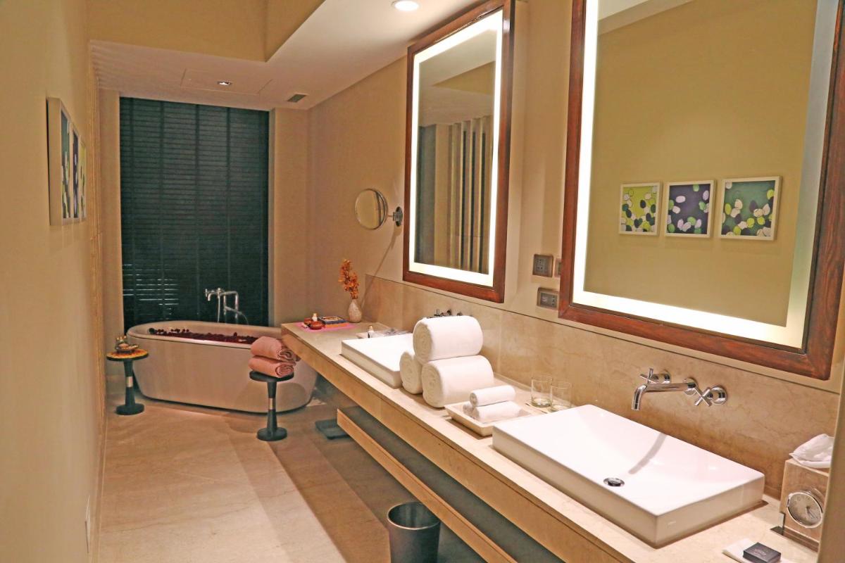 a bathroom with two sinks and a bath tub at Taj Bangalore in Devanahalli-Bangalore
