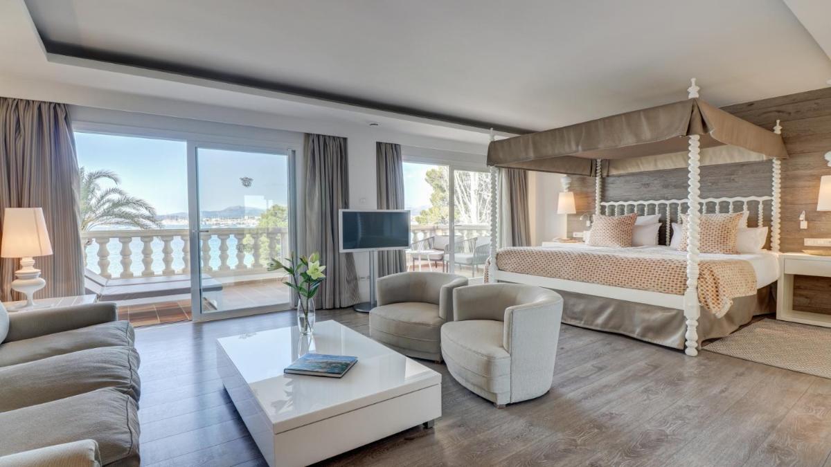 Un dormitorio con una cama y una sala de estar. en Hotel Illa d'Or & Club Apts 4* Sup, en Puerto Pollensa