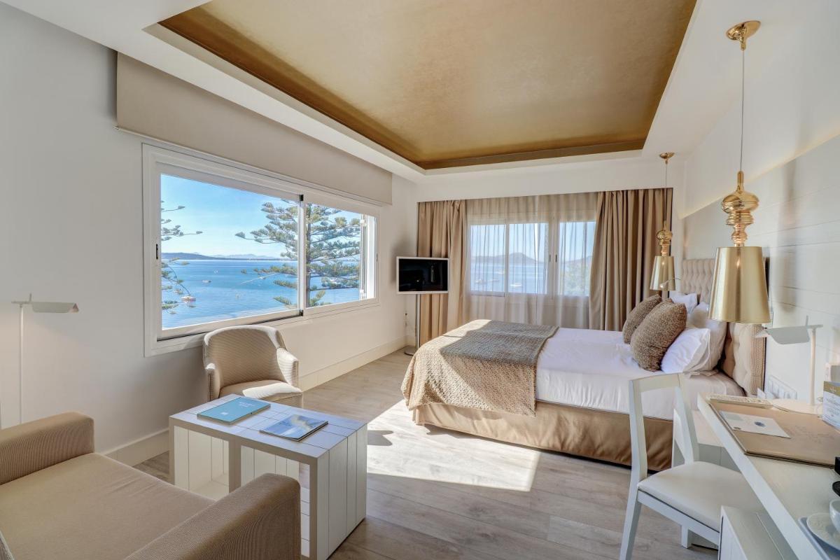 Una habitación de hotel con una cama y una ventana grande. en Hotel Illa d'Or & Club Apts 4* Sup, en Puerto Pollensa