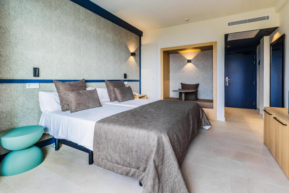 una habitación de hotel con dos camas y una mesa en Cabot Pollensa Park Spa, en Puerto Pollensa