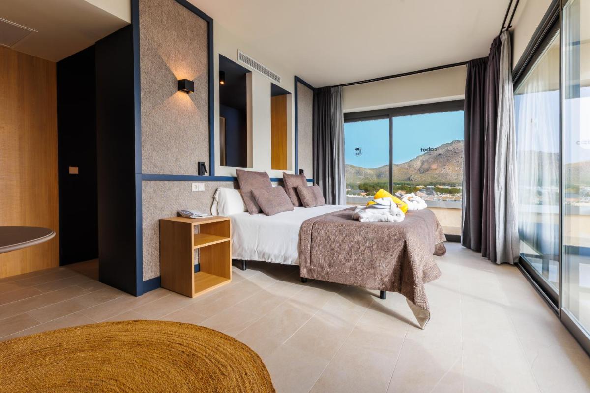 Un dormitorio con una cama y una ventana grande. en Cabot Pollensa Park Spa, en Puerto Pollensa