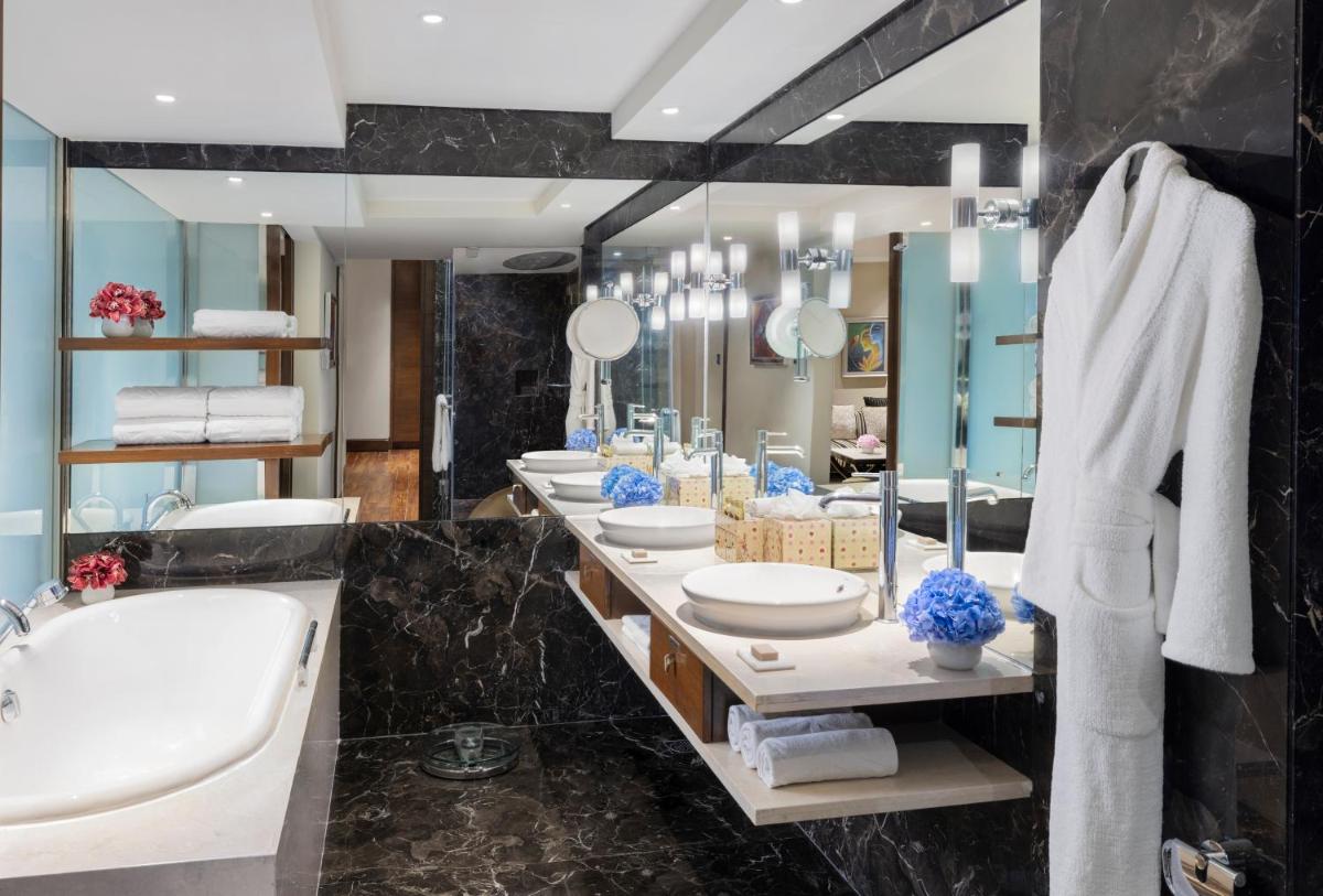 a bathroom with four sinks and a tub and a large mirror at Taj Palace, New Delhi in New Delhi a bathroom with four sinks and a tub and a large mirror at Taj Palace, New Delhi in New Delhi