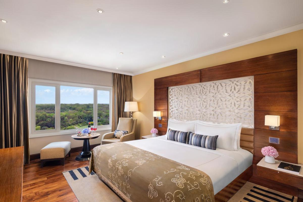 a hotel room with a large bed and a window at Taj Palace, New Delhi in New Delhi a hotel room with a large bed and a window at Taj Palace, New Delhi in New Delhi