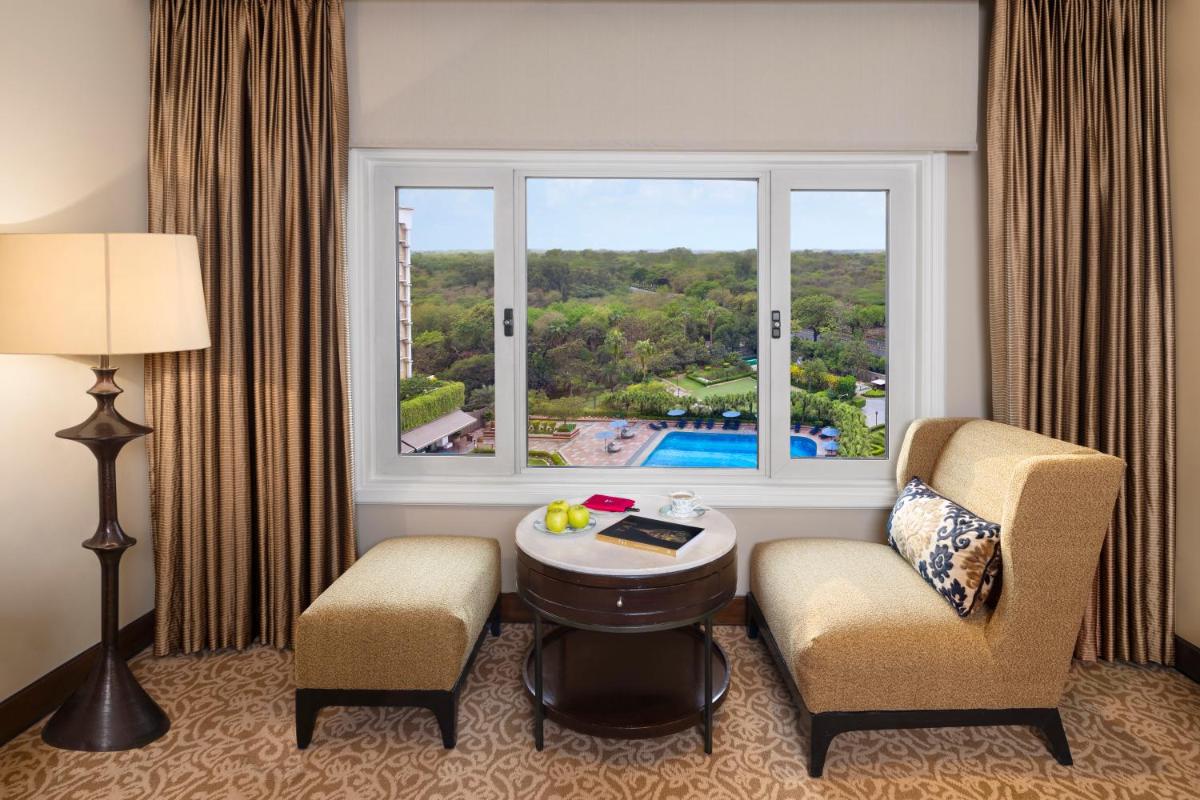 a room with two chairs and a table and a window at Taj Palace, New Delhi in New Delhi a room with two chairs and a table and a window at Taj Palace, New Delhi in New Delhi