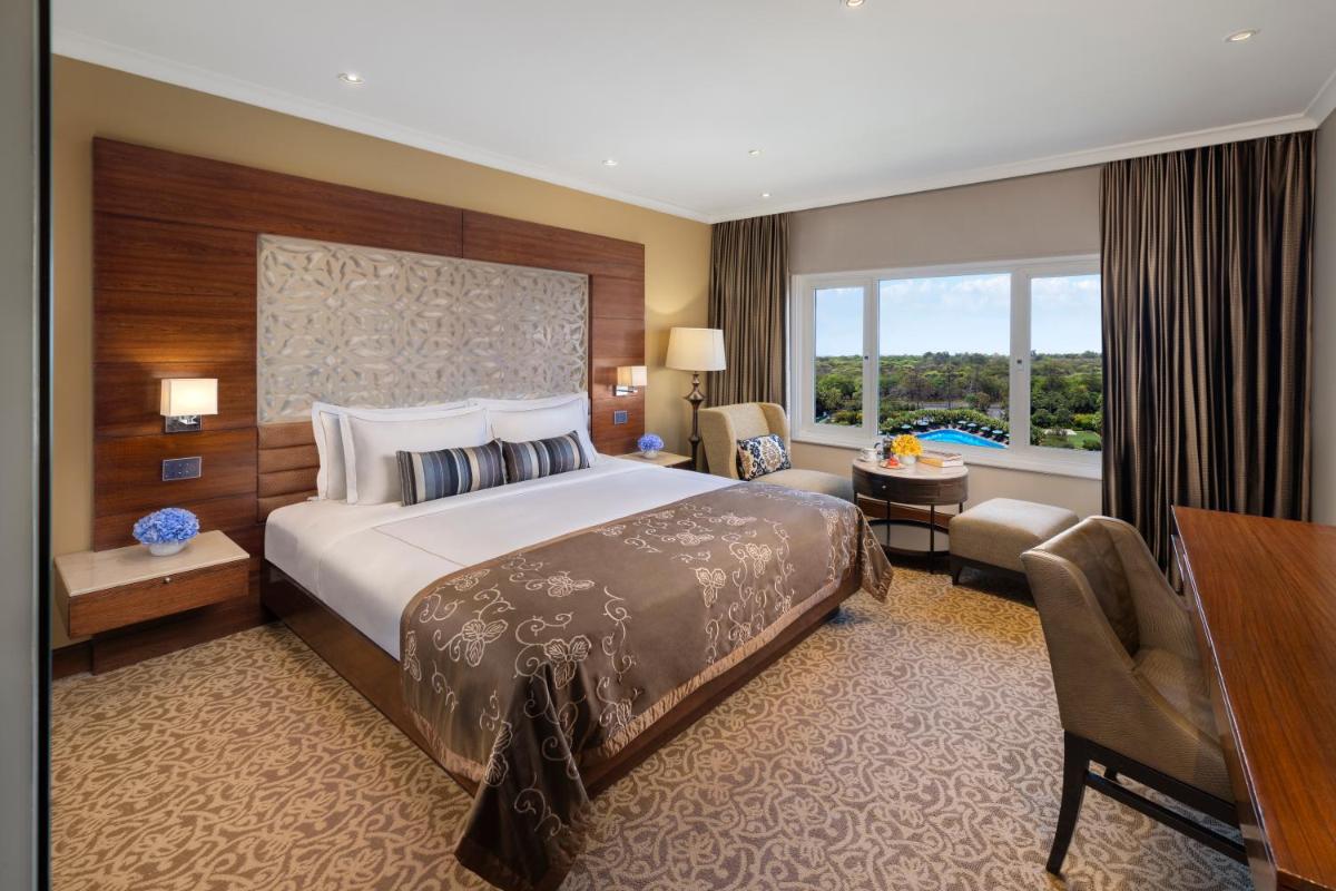 a hotel room with a large bed and a desk at Taj Palace, New Delhi in New Delhi a hotel room with a large bed and a desk at Taj Palace, New Delhi in New Delhi