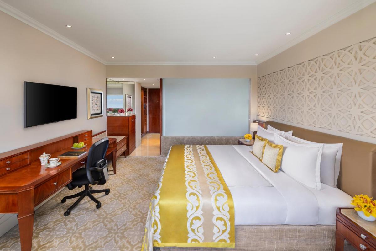 a hotel room with a large bed and a desk at Taj Palace, New Delhi in New Delhi a hotel room with a large bed and a desk at Taj Palace, New Delhi in New Delhi