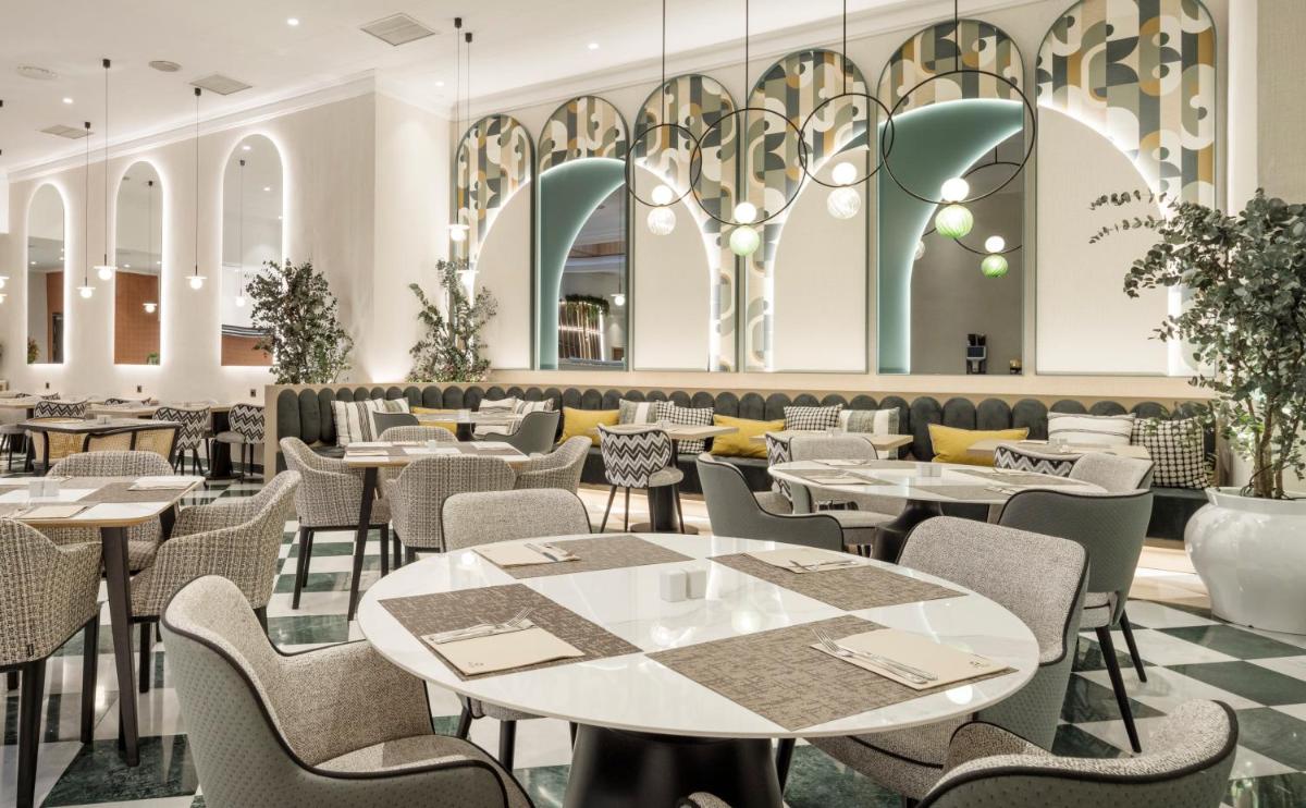 Un restaurante con mesas y sillas en una habitación. en Ilunion Les Corts Spa, en Barcelona
