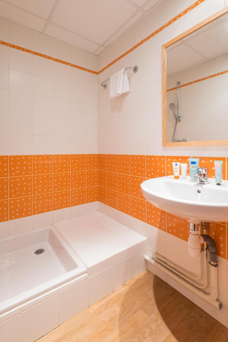 une salle de bain avec un lavabo et une baignoire dans l'établissement Résidence Pierre & Vacances la Corniche de la Plage, à Bénodet 33 autres photos