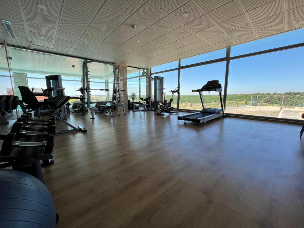 um ginásio com passadeiras e equipamento de exercício e uma grande janela em Hotel O Gato & Spa em Odivelas