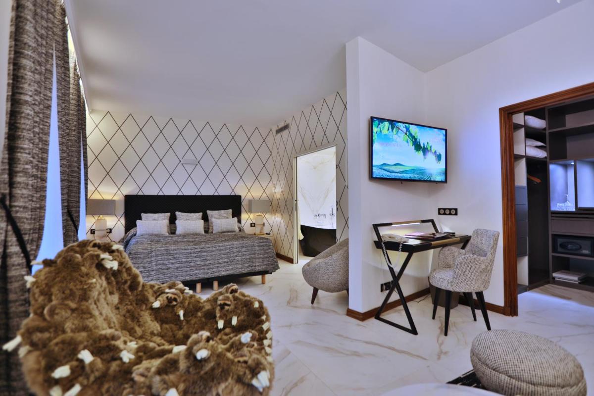 Télévision ou salle de divertissement dans l'établissement Hôtel Le Cep & Spa