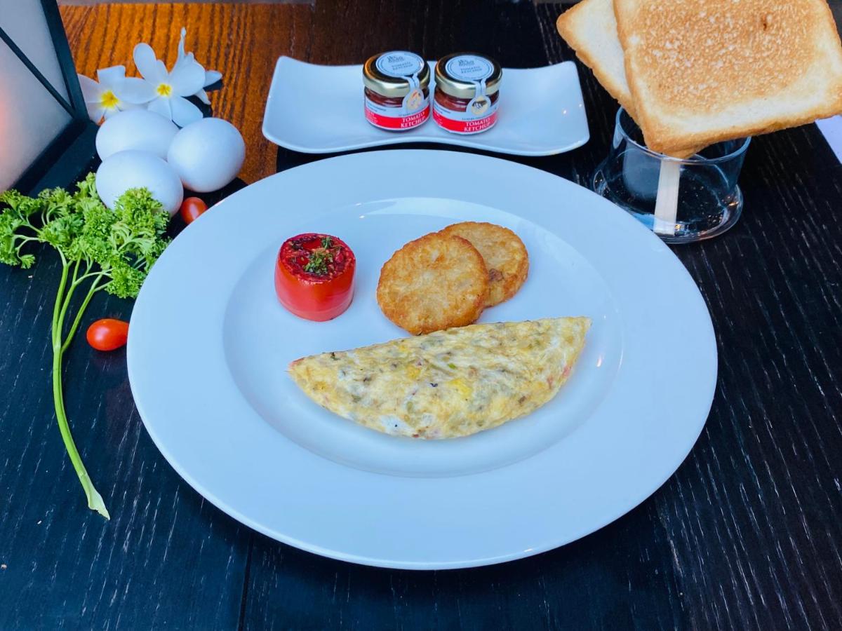 a white plate with a omelet and bread on a table at Hilton Chennai in Chennai