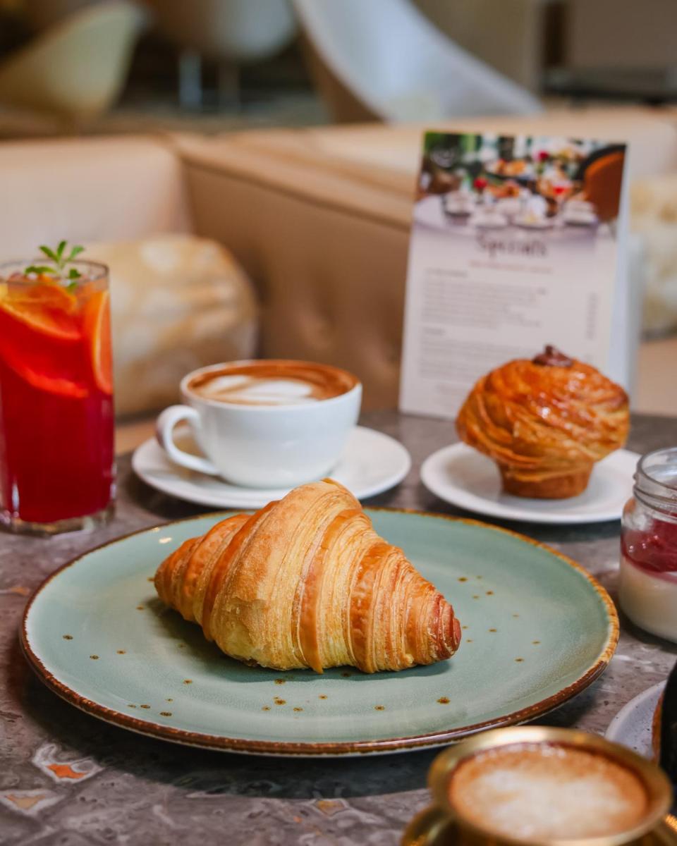 a plate with a croissant and a cup of coffee at Hilton Chennai in Chennai