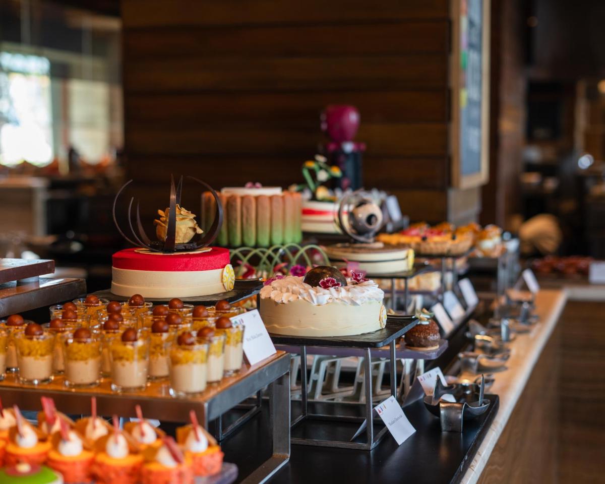 a buffet with cakes and other desserts on display at Hilton Chennai in Chennai
